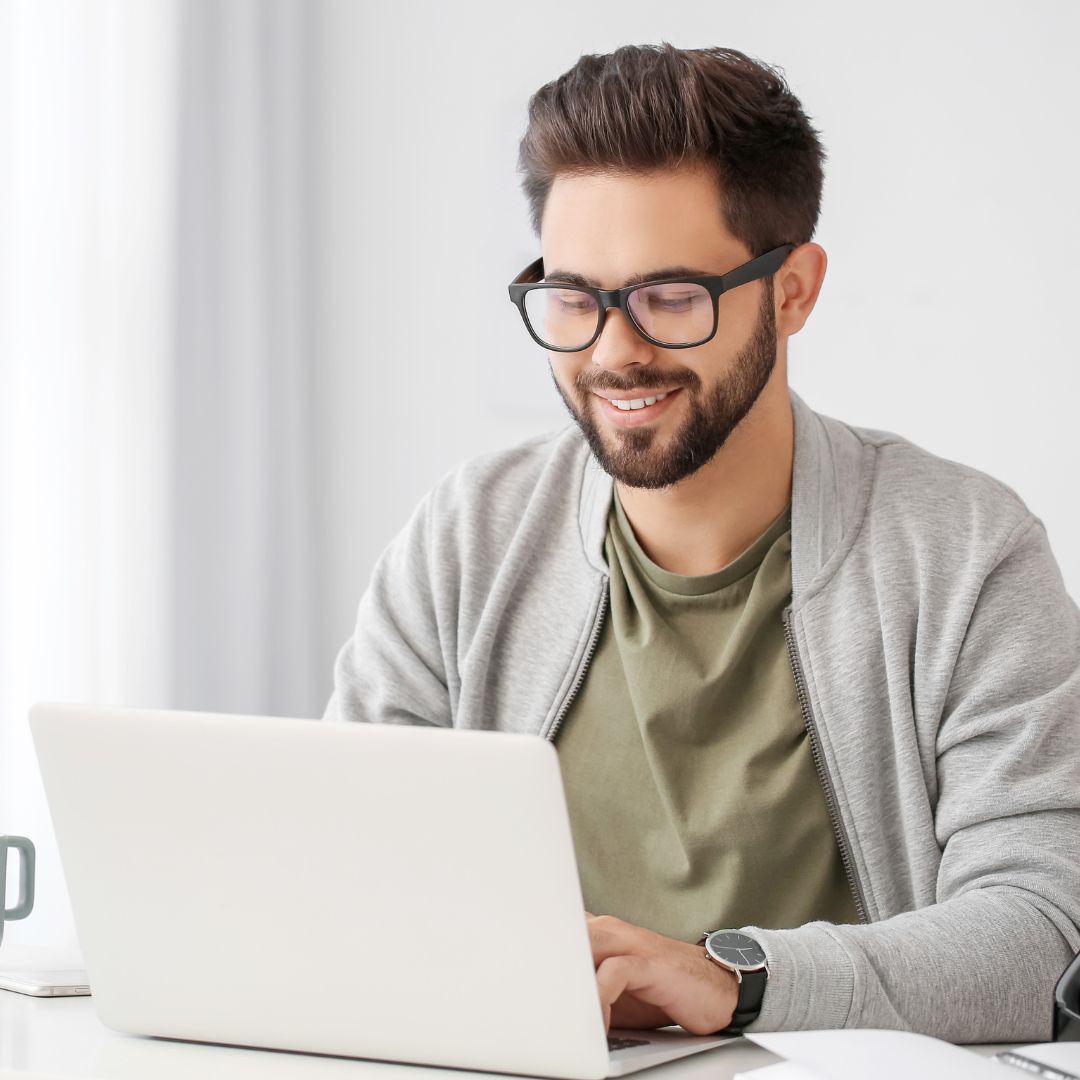 a man smiling while on his computer